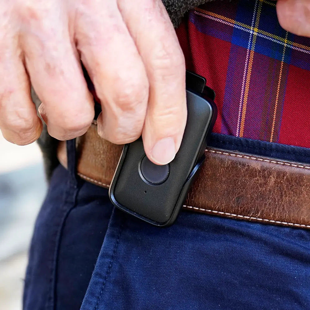 Person placing their Belle X device on their belt.
