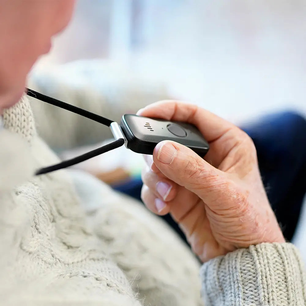 Person holding their Belle medical alert device. 